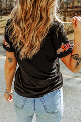 Camiseta negra con mangas cortas y cuello redondo bordado con flores