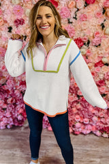 White drooping shoulder sweater and zipper on a quarter of a colored edge