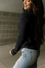 Alto Henley en tejido negro en relieve con un escote fronterizo