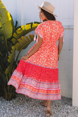 Robe longue taille empire à imprimé floral rouge avec manches nouées et pompons