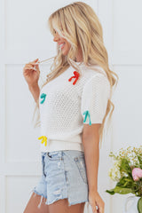 Pull blanc à col montant et nœud coloré