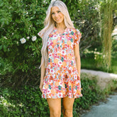 Vestido morado con estampado floral y cuello dividido, mangas flotantes