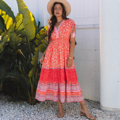 Robe longue taille empire à imprimé floral rouge avec manches nouées et pompons