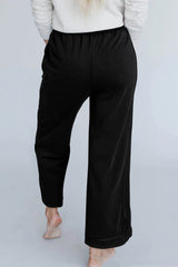 Grandes pantalones negros con costuras minerales y aparentes