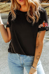 Camiseta negra con mangas cortas y cuello redondo bordado con flores