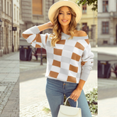 Pull à carreaux beige et blanc porté par un modèle