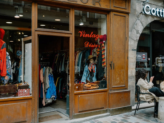 "Vitrine d'une franchise boutique de vêtements vintage, présentant des articles de mode anciens et tendances."
