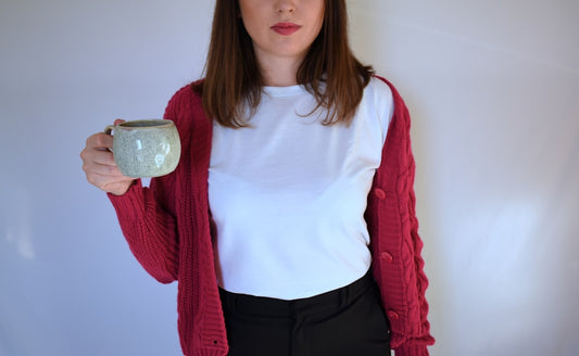 Femme tenant une coupe en argent, vêtue d'un gilet femme en maille vintage.