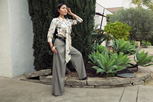 Une femme porte des vêtements femme confortables et élégants, un pantalon large et un top à motifs, pour un look féminin élég