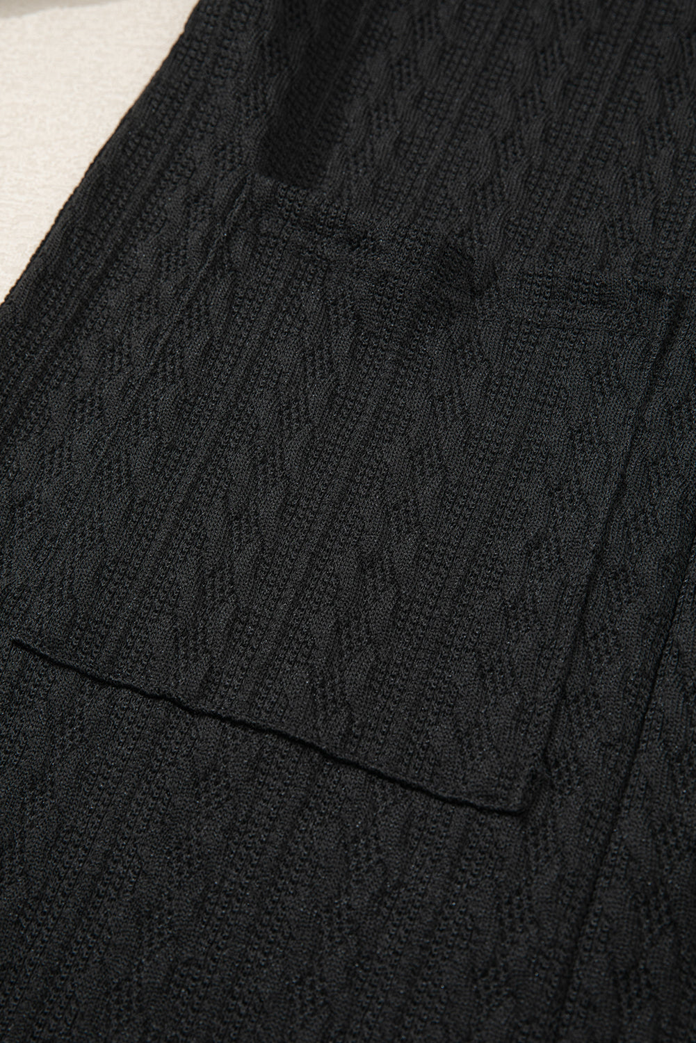 Cardigan noir ouvert sur le devant avec poches latérales en tricot texturé