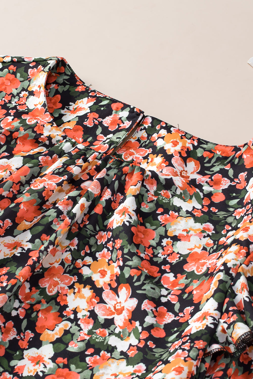 Blouse florale orange à volants et poignets froncés