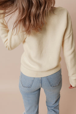 Beige knitted sweater with ribbed edges with flower pattern