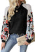 Black ribbed blouse with long sleeves and floral patchwork