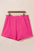 Large pink textured shorts with rolled edges and ruffles, elastic waist