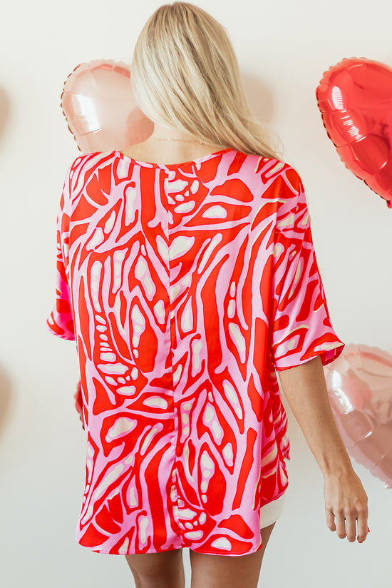 Oversize red blouse with abstract print, V-neck, bat handles