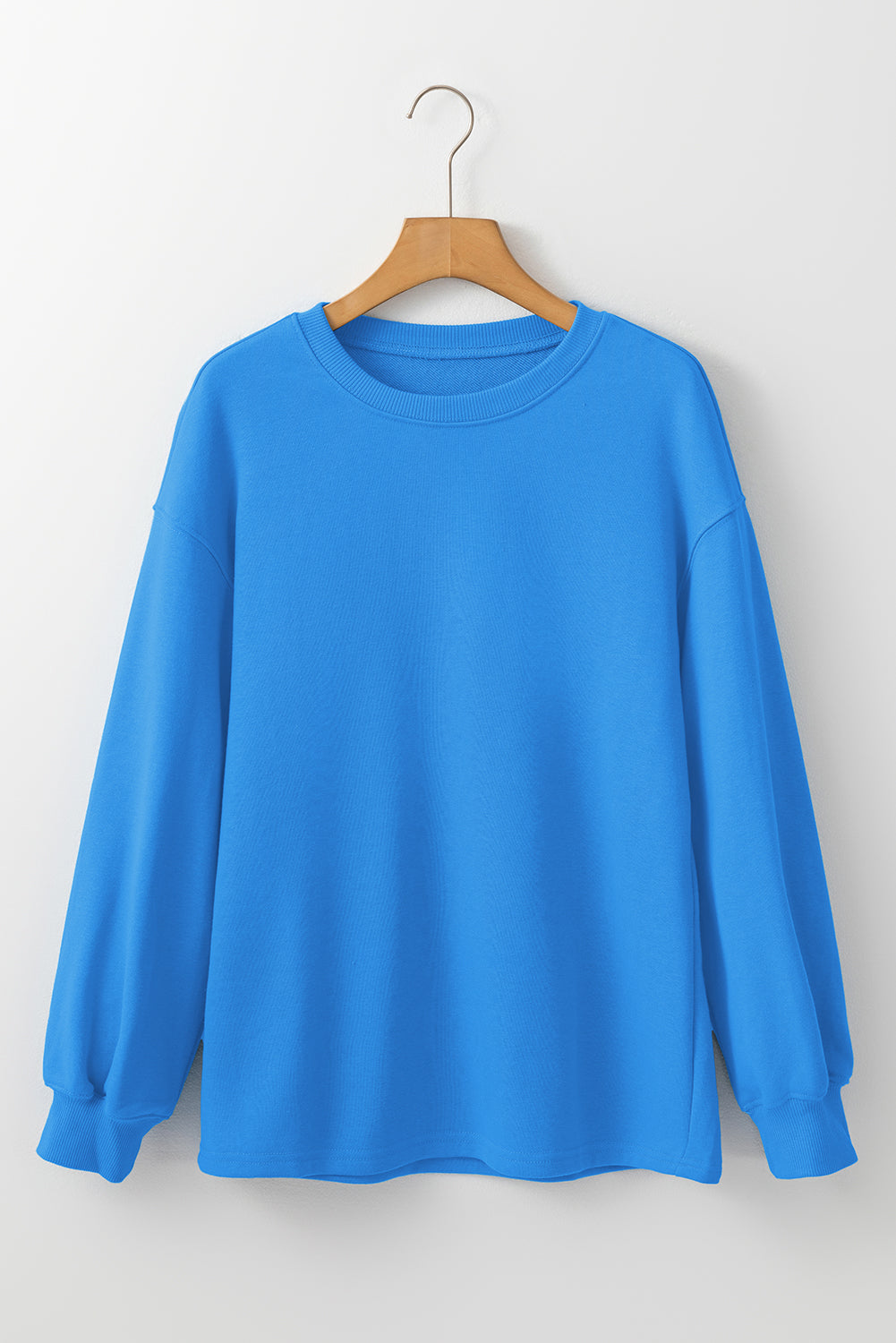 Sudadera básica con manga larga y hombros que caen en un cielo azul liso