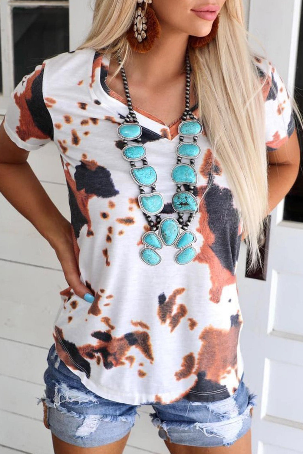 Camiseta blanca con mangas cortas y cuello en V estampado con patrón de vaca