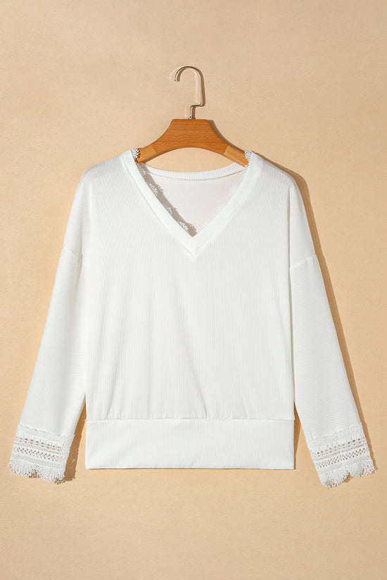 White high with long sleeves and V -neck with lace border and ribbed texture