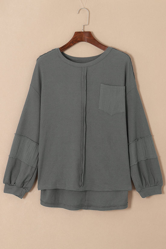 Grey waffle knit top with bubble sleeves and patchwork with exposed seams