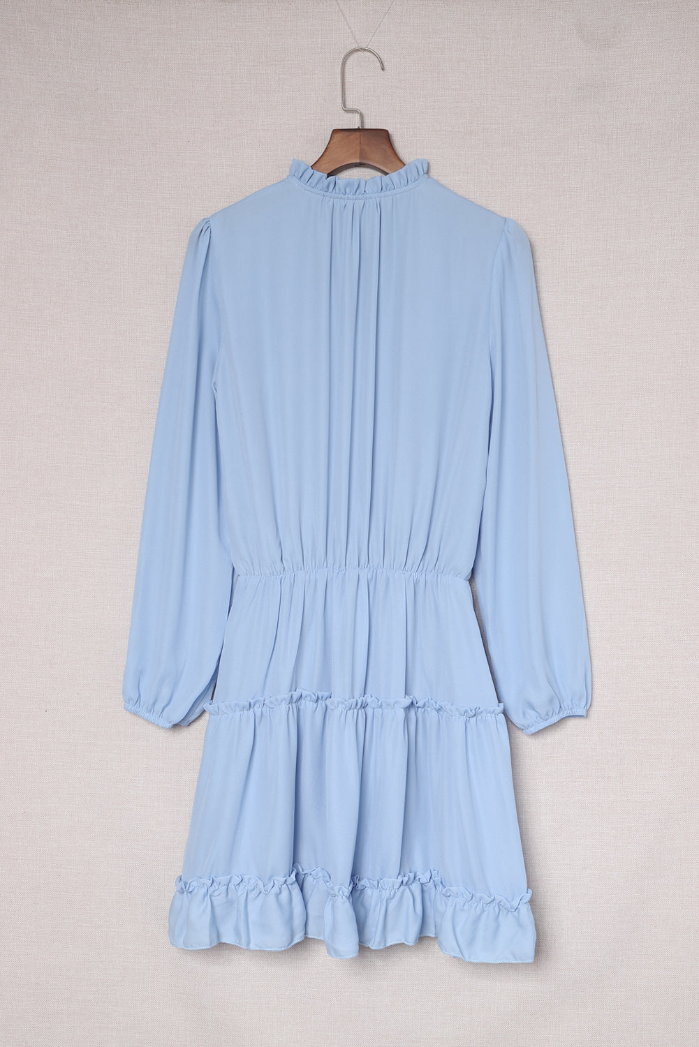 Mini-robe bleu clair à col en V et manches longues à volants et volants