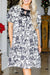 Vestido negro de longitud media con estampado floral y mangas hinchadas, grandes, con nudo