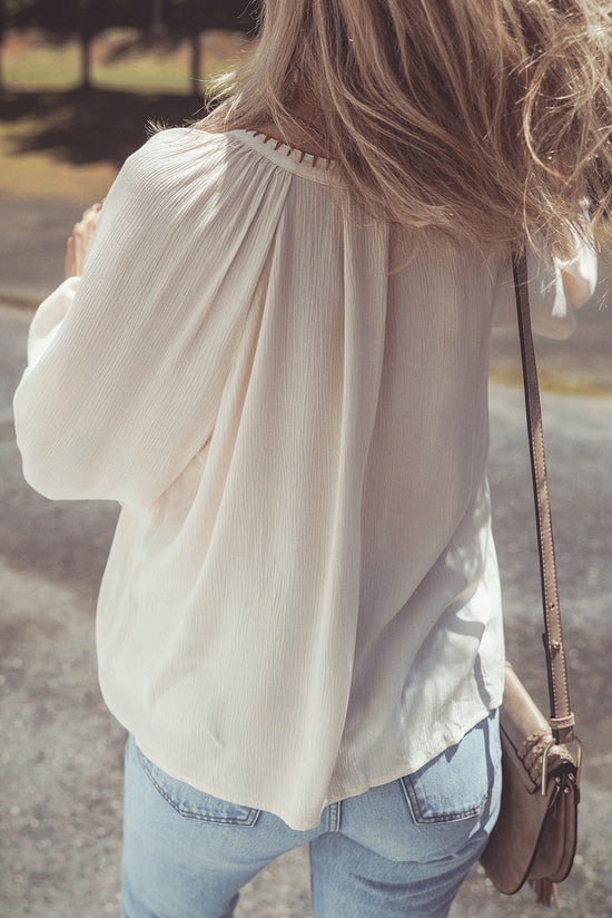 Beige loose shirt with puffy textured sleeves embroidered with flowers