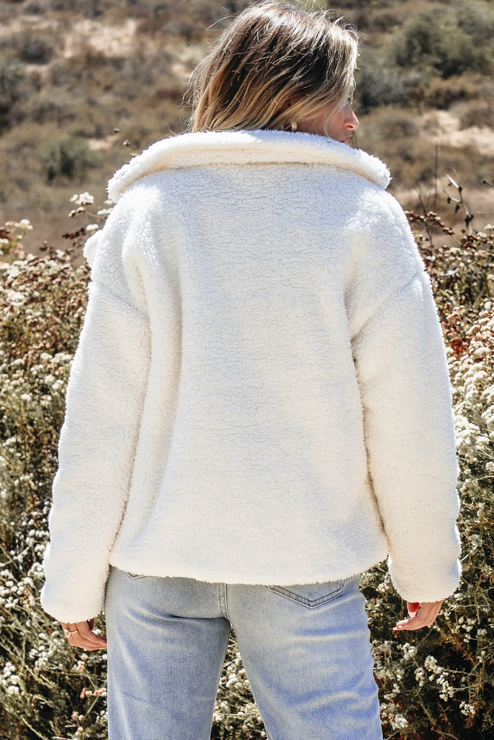 Veste beige en fausse fourrure avec poches boutonnées et col à revers