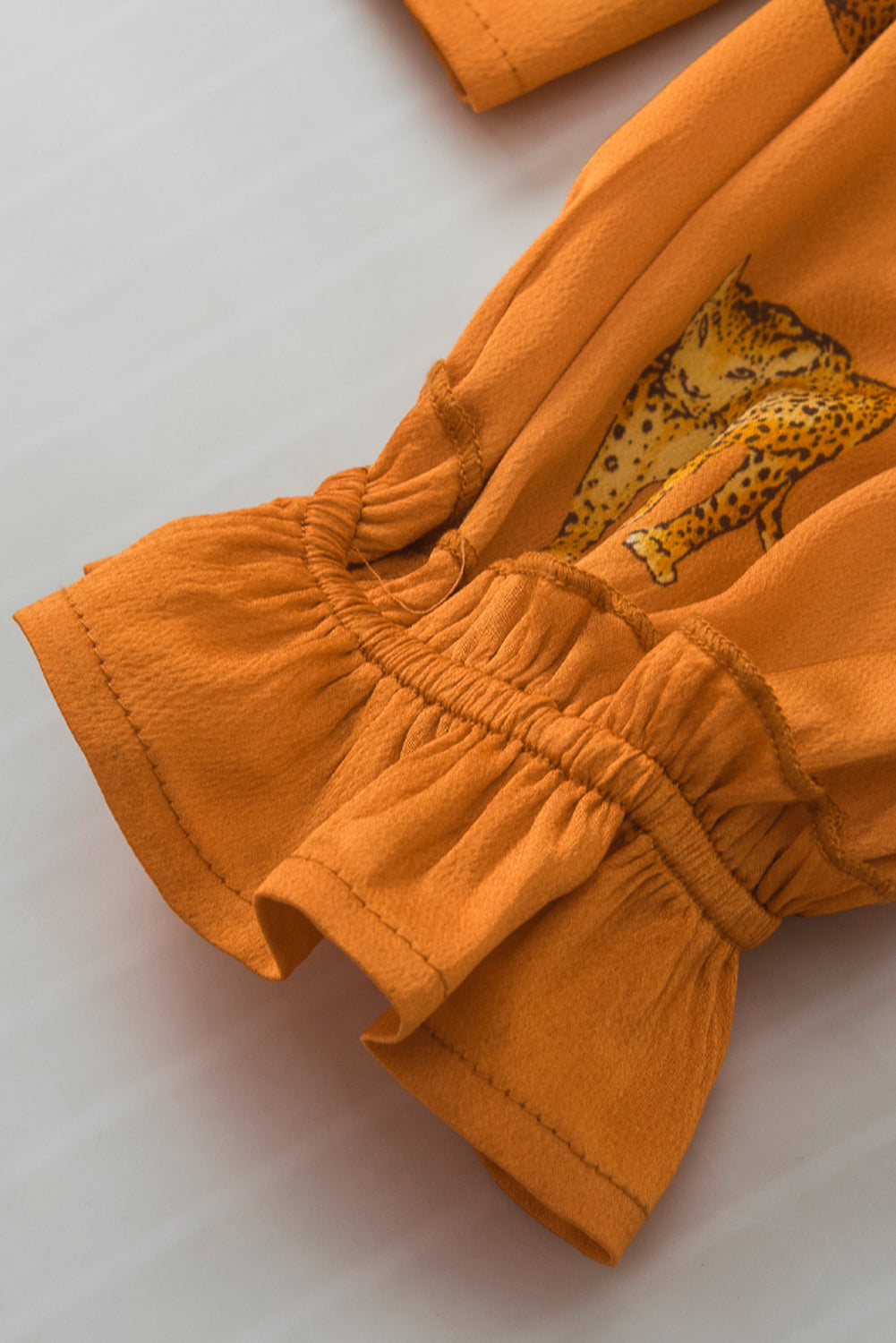 Blouse orange à manches volantées et imprimé guépard