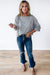 Light gray long sleeve sweater top with raw hem in waffle patchwork