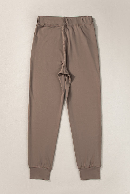 Dark brown jogging pants with pockets and tightening cord at the waist