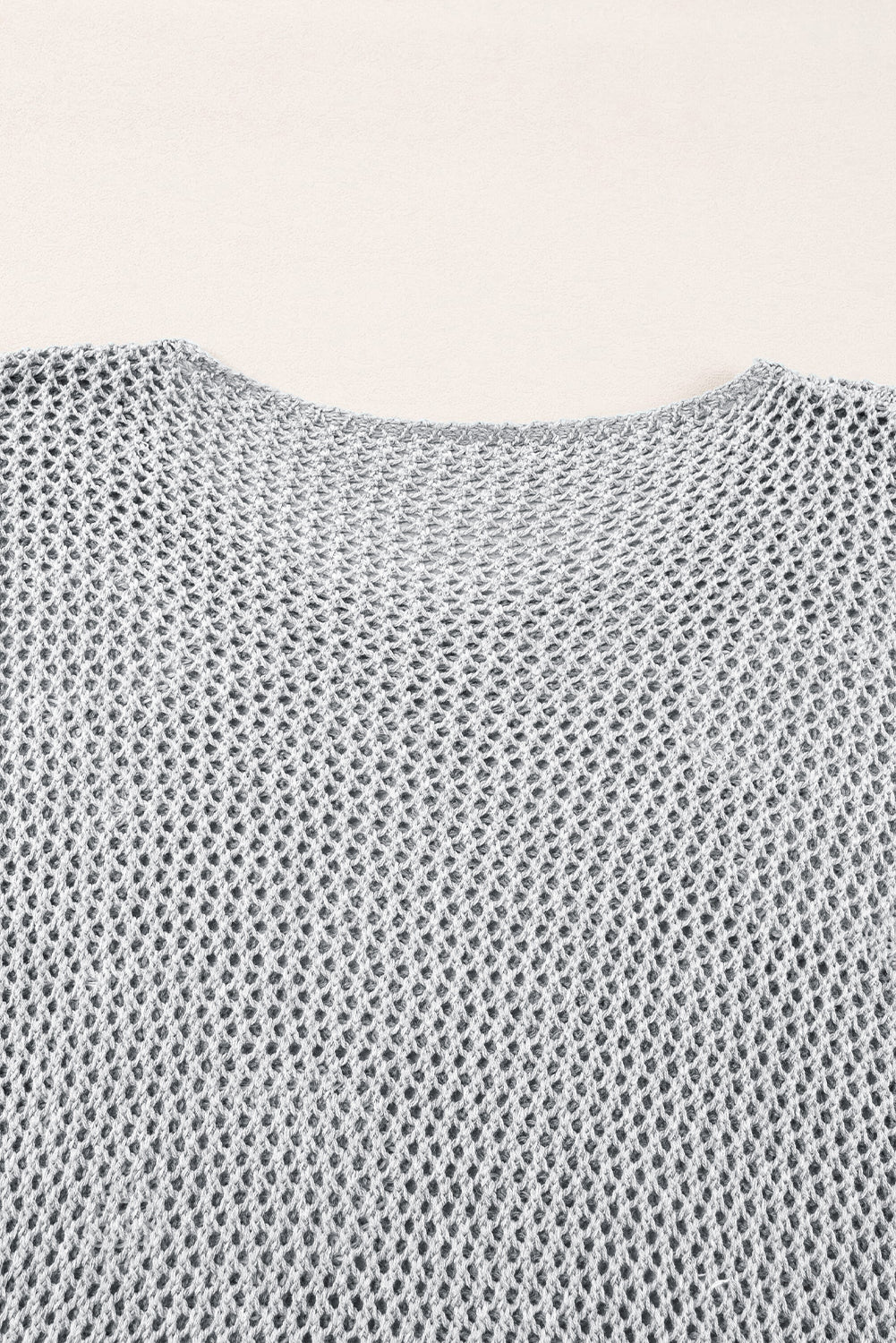 Light gray sweater with drooping shoulders in openwork knitting with large flowers
