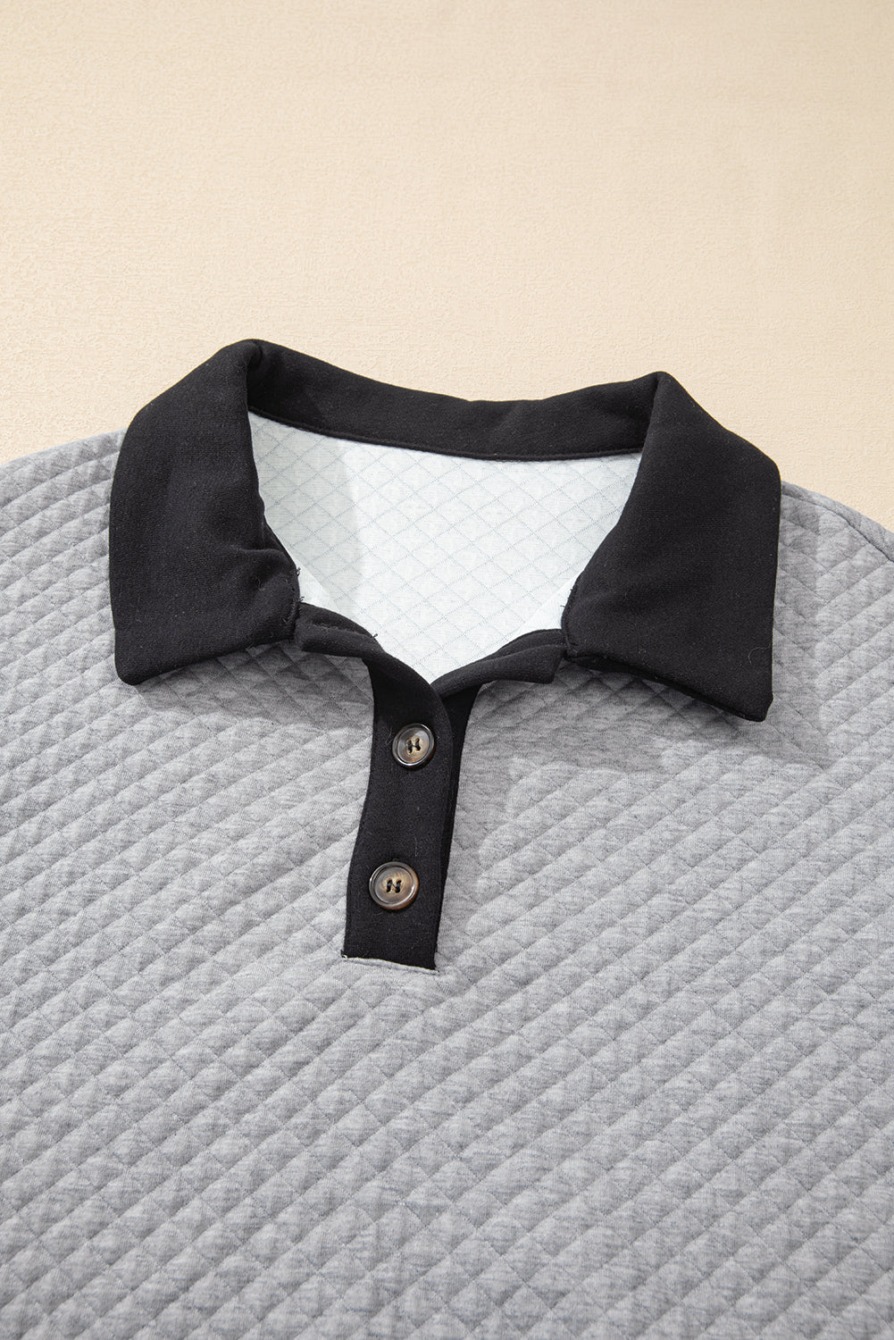 Sudadera gris texturizada gris claro en el bloque de color de los bordes y collar abotonado