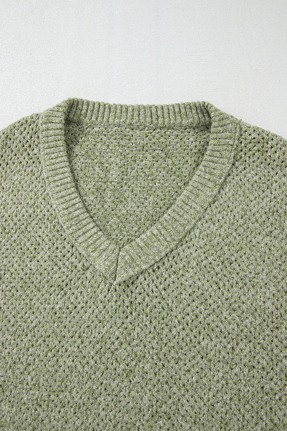 Pull ample à œillets vert jungle, col en V, épaules tombantes