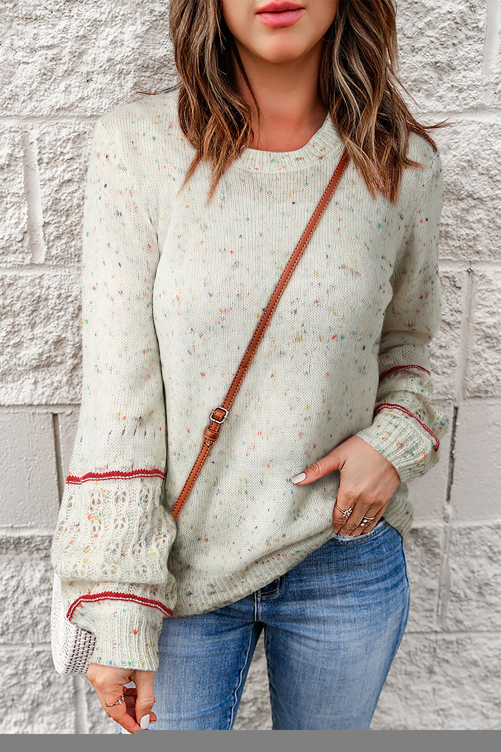 White sweater with patterned sleeves and pilled details