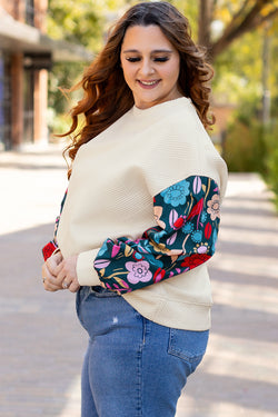 White textured sweater top with patchwork sleeves and large flowers