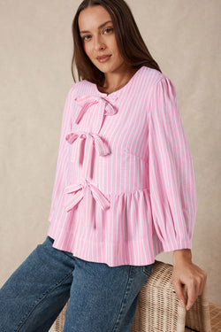 Striking pink blouse and bow tie on the front, round neck, puffy sleeves