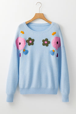 Light blue knitted sweater with ribbed edges with flowers pattern