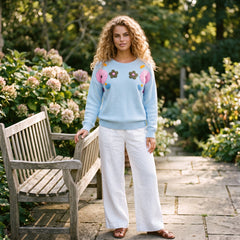 Light blue knitted sweater with ribbed edges and floral pattern