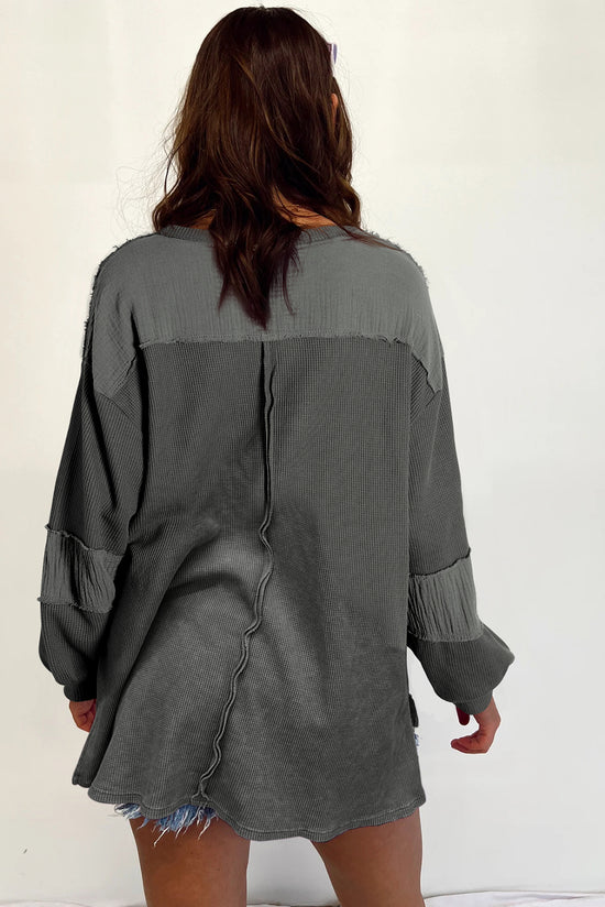 Grey waffle knit top with bubble sleeves and patchwork with exposed seams