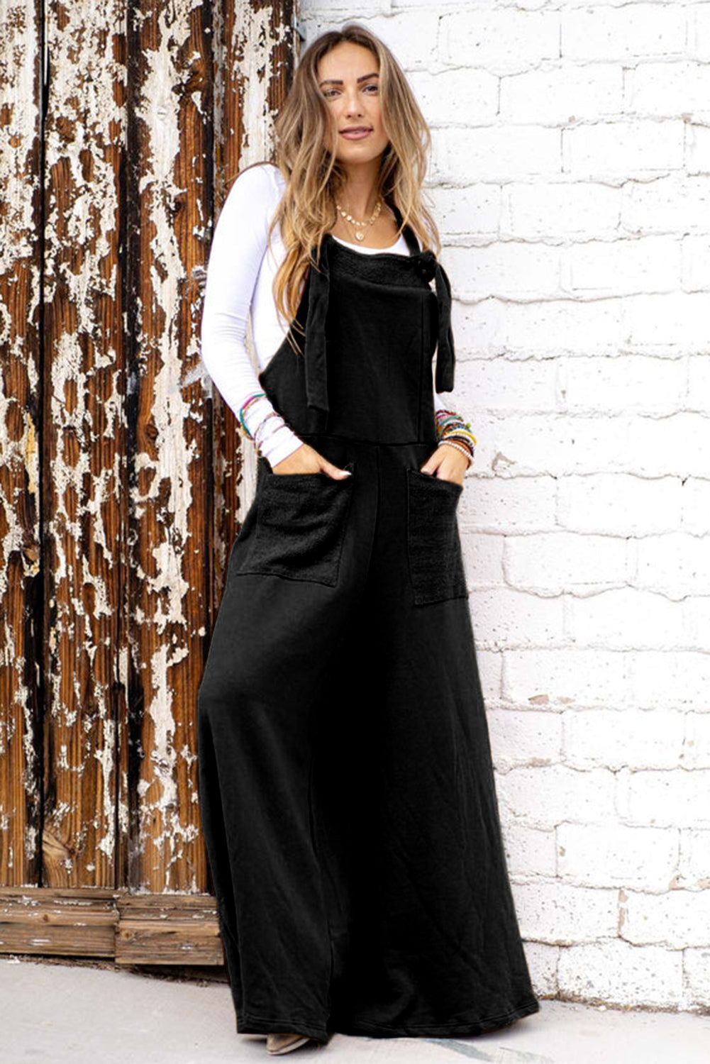 Black wide leg jumpsuit with knotted straps and patch pocket