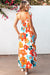 Long orange floral dress with straps tied at the smocked bust