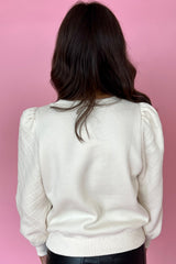 Sudadera blanca unida con mangas hinchadas y cuello redondo