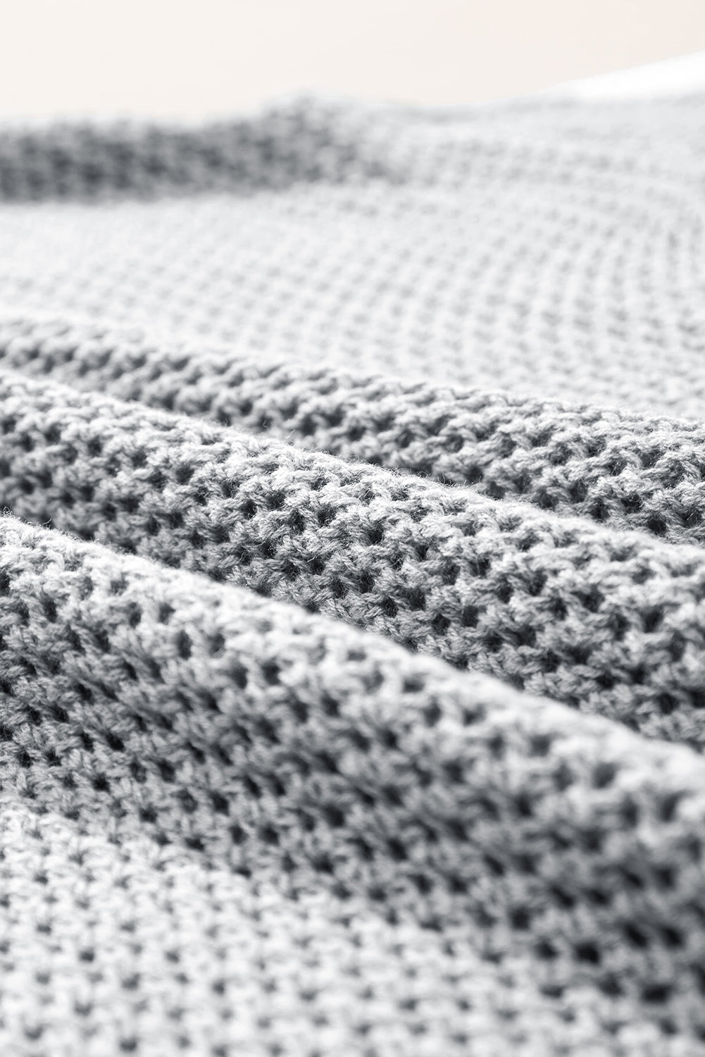 Light gray sweater with drooping shoulders in openwork knitting with large flowers