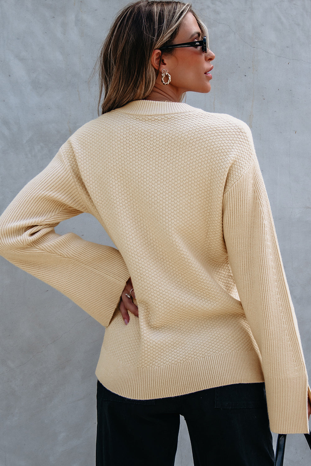 Loose-fitting parchment textured knit sweater with slit cuffs and dropped shoulders