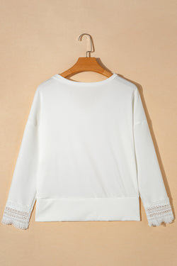 White high with long sleeves and V -neck with lace border and ribbed texture