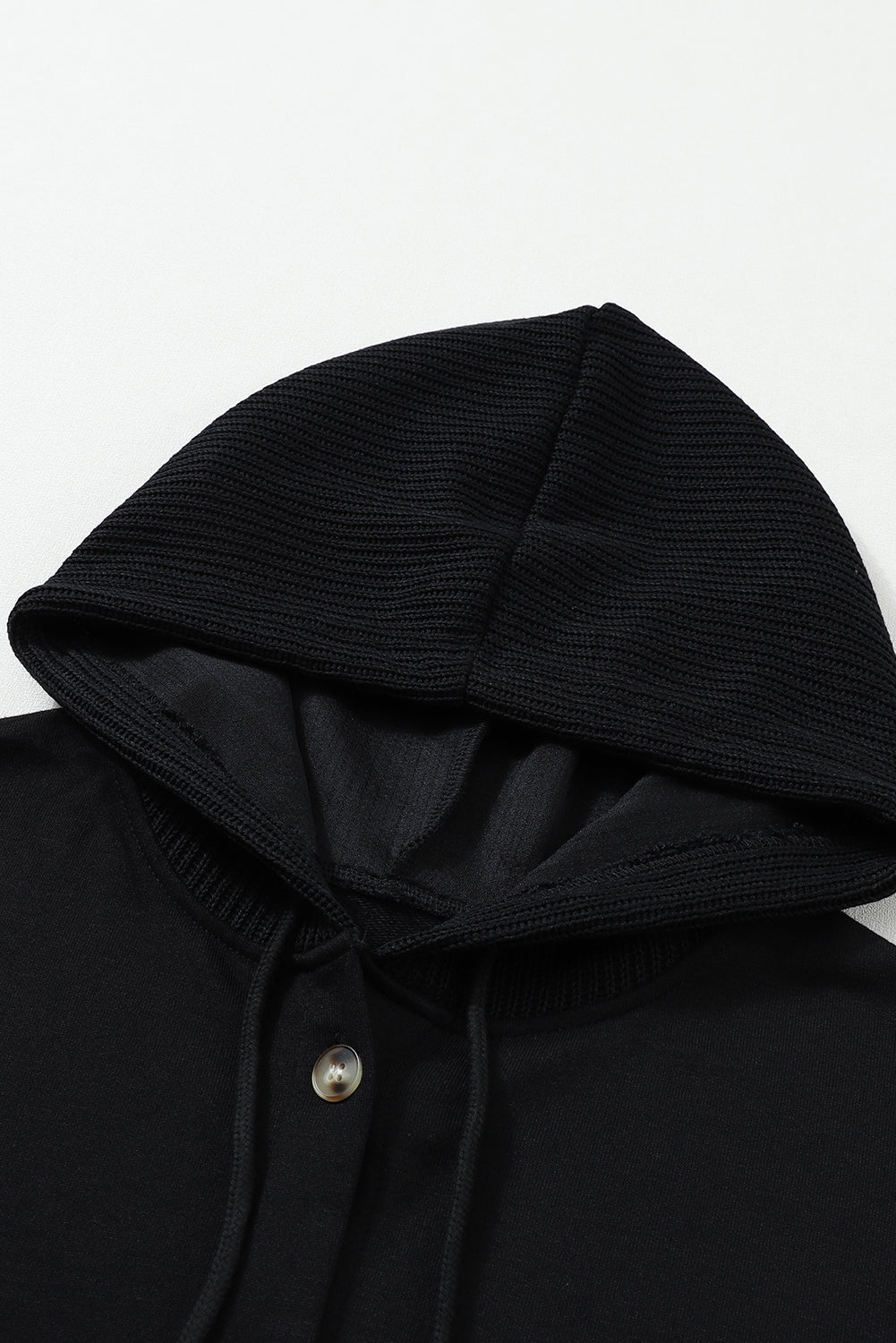 Veste à capuche noire boutonnée à manches tricotées contrastées