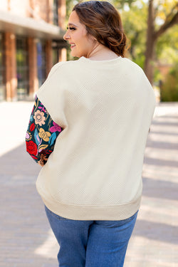 White textured sweater top with patchwork sleeves and large flowers