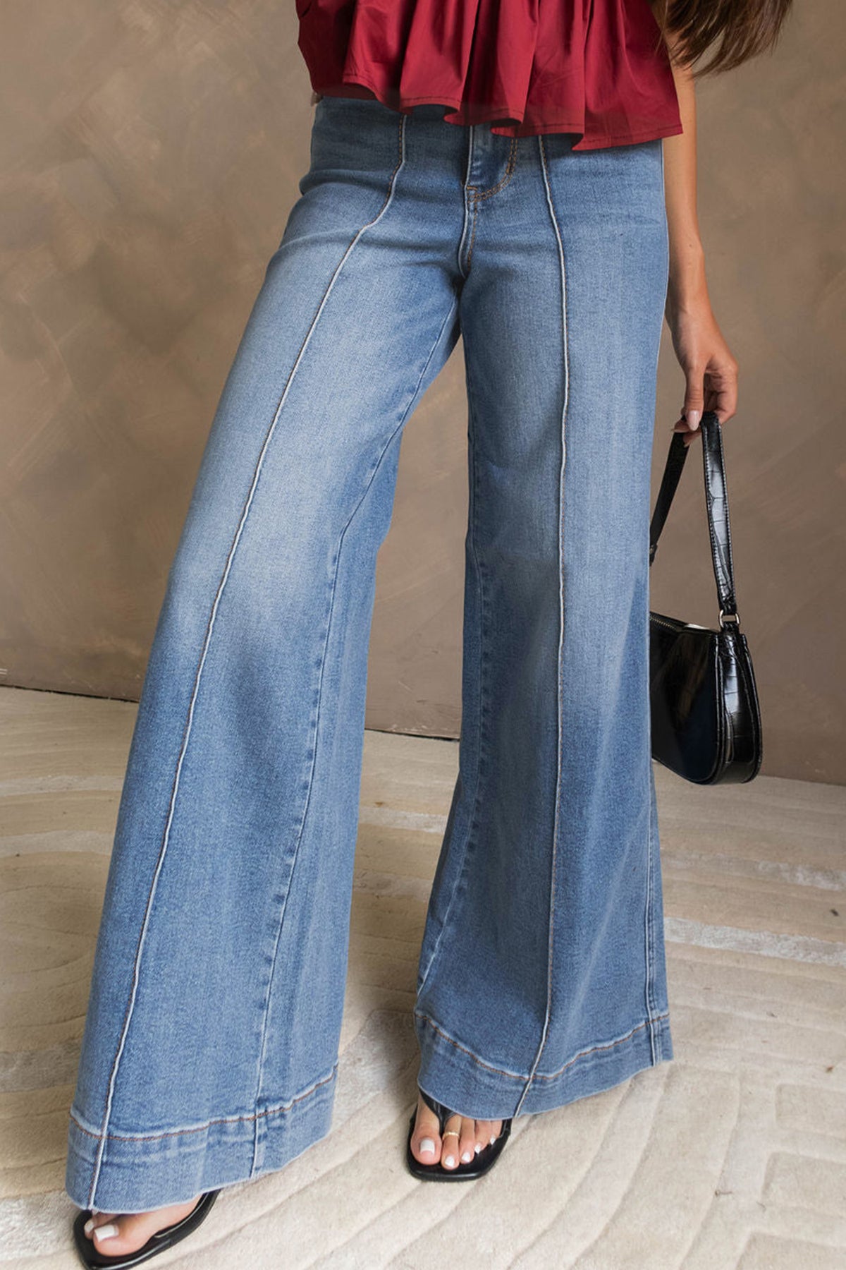 Jean évasé bleu à taille haute, passepoils et coutures apparentes