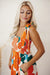 Long orange floral dress with straps tied at the smocked bust