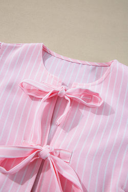 Striking pink blouse and bow tie on the front, round neck, puffy sleeves